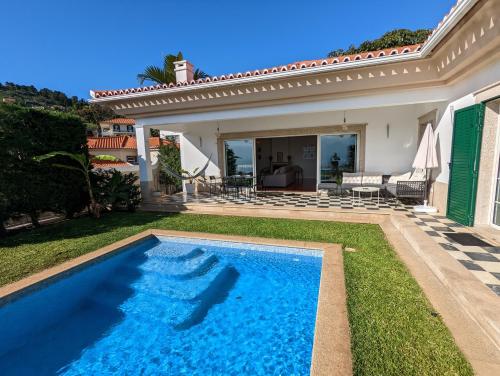 a swimming pool in the yard of a house at Casa Roc Madeira - 5 Bedrooms - Ocean and City Views - Private Heated Pool in Funchal