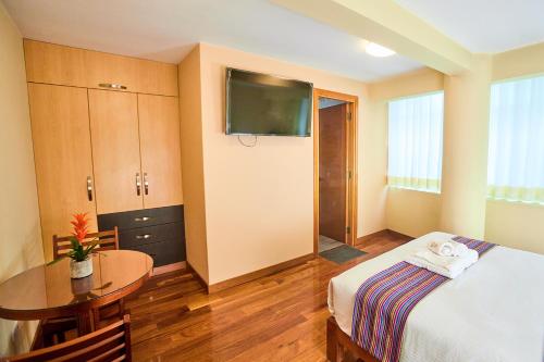 Habitación de hotel con cama y mesa en Samkauta Hotel & Suite, en Juliaca