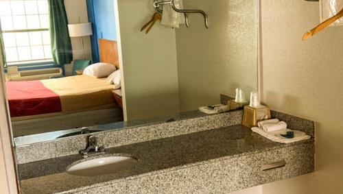 - une salle de bains avec lavabo dans une chambre d'hôtel dans l'établissement Luxury Inn Forrest City, à Forrest City
