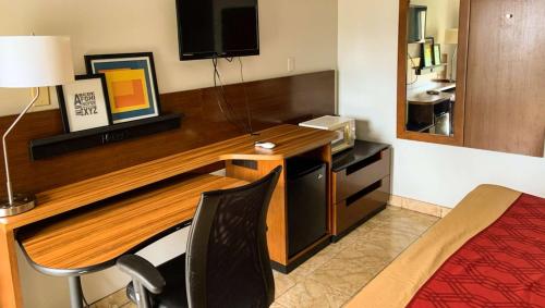 a hotel room with a desk and a bed at Luxury Inn Forrest City in Forrest City