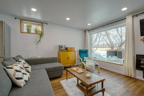 a living room with a couch and a table at The Ox + Bow in Portage La Prairie