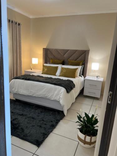 1 dormitorio con 1 cama grande con almohadas de oro en Isibani luxury apartment, en Richards Bay