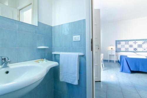Baño azul con lavabo y cama en Tenuta De Marco, en Presicce