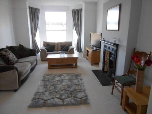 ein Wohnzimmer mit einem Sofa und einem TV in der Unterkunft Hillsborough View in Ilfracombe