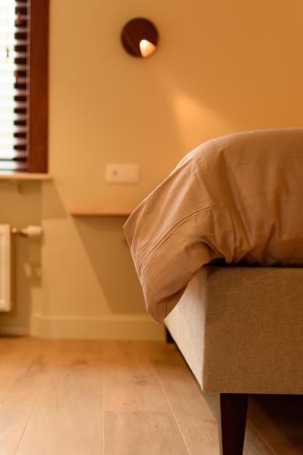 a room with a couch and a light on the wall at 't Knus Gewilg in Avelgem