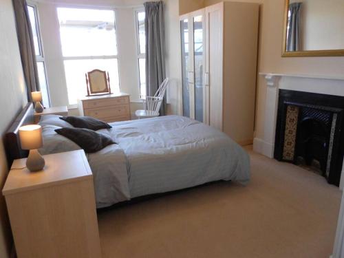 ein Schlafzimmer mit einem großen Bett und einem Kamin in der Unterkunft Hillsborough View in Ilfracombe