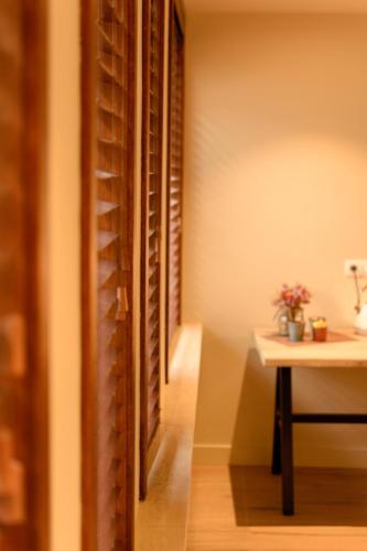 a room with a table and a wall with wine racks at 't Knus Gewilg in Avelgem