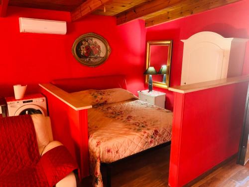 a red bedroom with a bed and a mirror at Anzio a picco sul mare! in Anzio