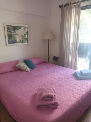 un lit rose avec une couverture rose en haut dans l'établissement TODO AL ALCANCE DE LA MANO, à Mendoza
