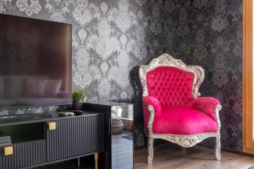 a red chair in a room with a tv at Once Upon A Time in Leukerbad