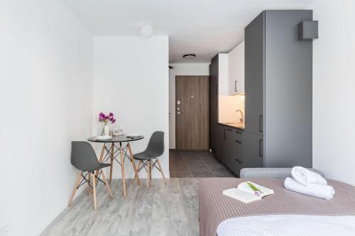 sypialnia z 2 łóżkami, stołem i krzesłami w obiekcie River To The City - Studio 8 Apartment w Wilnie