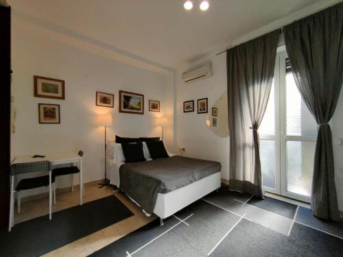 um quarto com uma cama, uma mesa e uma janela em Short rent milan em Milão