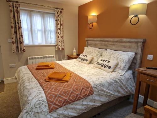 a bedroom with a bed with two towels on it at The Pelican Inn in Devizes