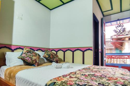 1 dormitorio con 1 cama con colcha de flores en Mythos Hostal, en Filandia