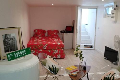 a living room with a red bed and a table at Superbe et vaste Logement(F) avec WIFI Gratuit in Drancy