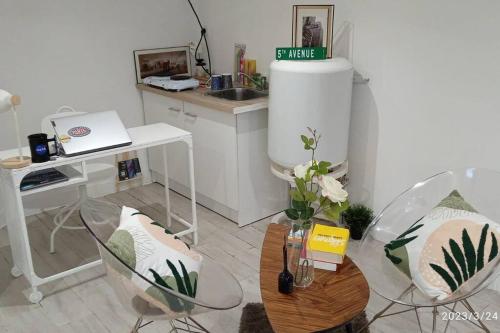 a kitchen with two chairs and a table and a counter at Superbe et vaste Logement(F) avec WIFI Gratuit in Drancy