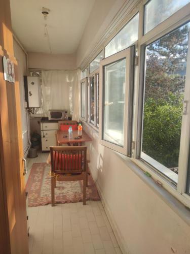 um quarto com uma mesa e janelas numa cozinha em İstanbul Üsküdar oda em Istambul