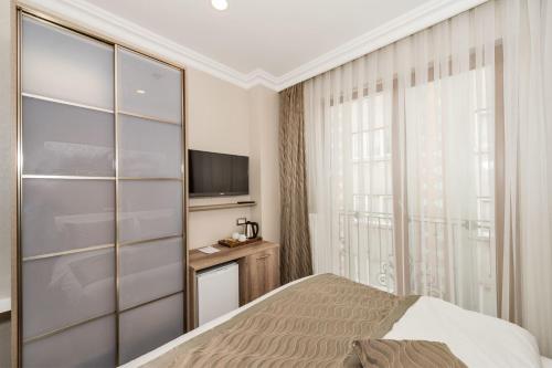 a bedroom with a bed and a television at Alphonse Hotel in Istanbul