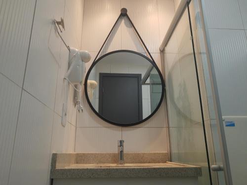 La salle de bains est pourvue d'un miroir et d'un lavabo. dans l'établissement No centro de Porto de Galinhas Praia Flats Temporada - Di Maré 104, à Porto de Galinhas