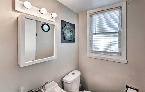 a bathroom with a toilet and a mirror and a window at Family-Friendly Rockford Home with Private Yard! in Rockford