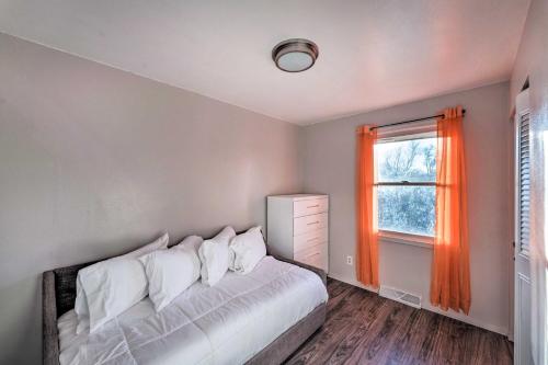 a bedroom with a bed and a window with an orange curtain at Family-Friendly Rockford Home with Private Yard! in Rockford