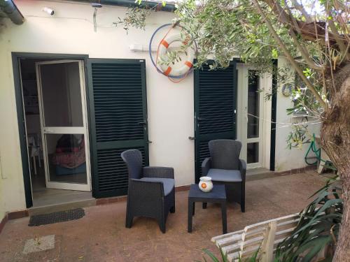a pair of chairs and a table in front of a house at La Dependance in Centro in Follonica