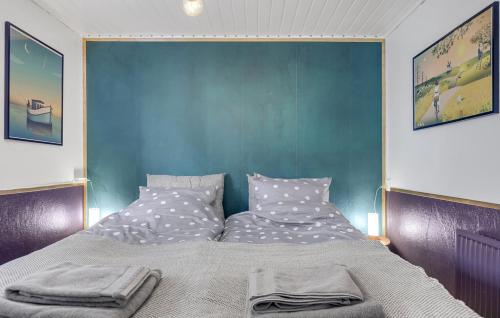 1 dormitorio con 1 cama grande y pared azul en Heidis Residence-Sandkaas, Bornholm, en Allinge
