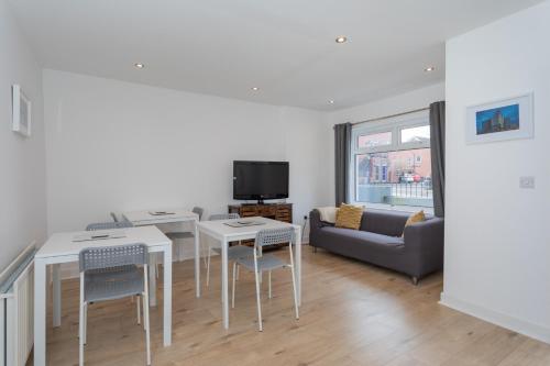 a living room with a table and chairs and a couch at The Avenue Belfast in Belfast