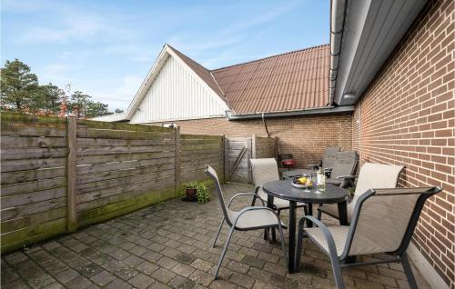 a patio with a table and chairs and a fence at Holiday Home Blåvandvej Blåvand Xii in Blåvand