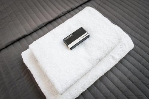 a remote control sitting on a white towel on a bed at Plantage Garden Apartments in Amsterdam