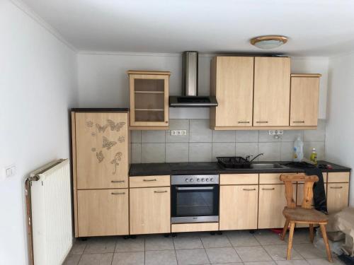 eine Küche mit Holzschränken und einem Herd in der Unterkunft Feel Natural and Relaxed in a 3 Bedroom Apartment in Gyongyosfalu in Gyöngyösfalu