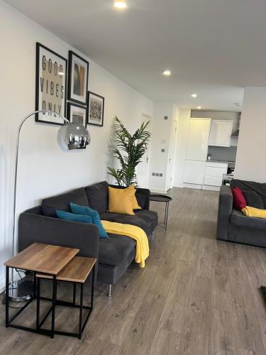 a living room with a couch and a table at Modern East London Apartment in London