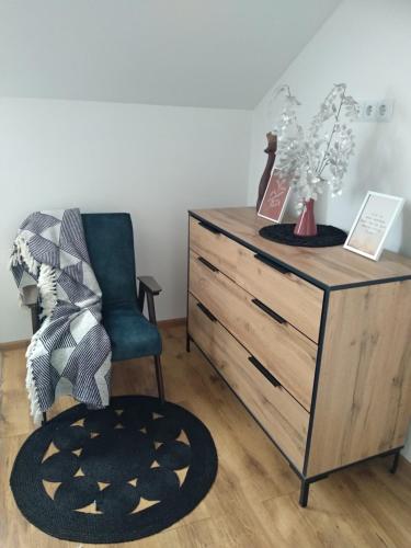 a bedroom with a dresser and a chair and a table at Old Town Loft Apartments in Kamianets-Podilskyi