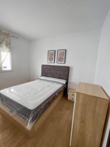 1 dormitorio con 1 cama y suelo de madera en RockSide Residences Suites La Línea N4 en La Línea de la Concepción
