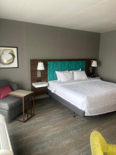 a hotel room with a bed and a couch at Hampton Inn By Hilton Kingston in Kingston