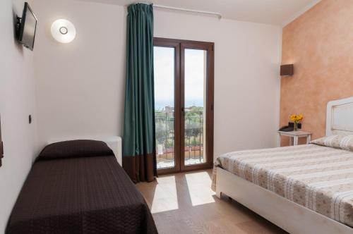 a bedroom with a bed and a large window at Hotel Donna Carmela Sede Unica a Sciacca in Sciacca