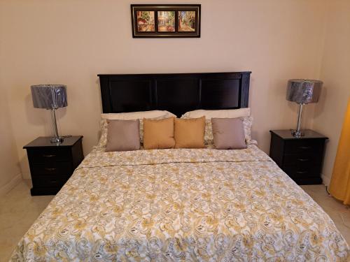 a bedroom with a large bed with two lamps at palmview estate townhouse in Mammee Bay