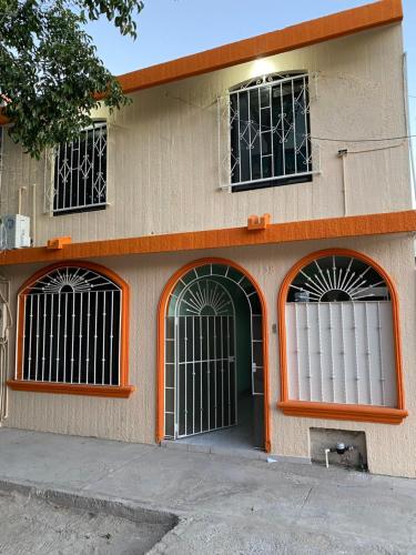a building with three windows with bars on it at Alojamiento Vacacional Casa Conchalito in La Paz