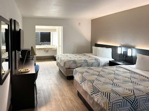 um quarto de hotel com duas camas e uma televisão em Motel 6-Pooler, GA - Savannah Airport em Savannah