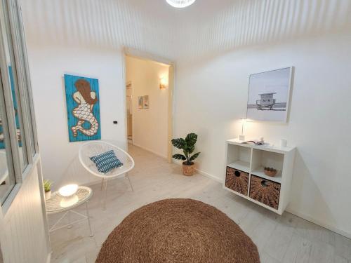 een woonkamer met een tafel en een stoel bij Magellano Suite. Fronte Mare + Free Park + Wi-Fi in Porto Empedocle