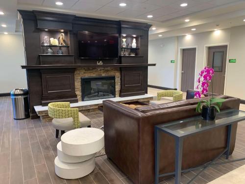 a living room with a fireplace and a tv at Best Western Plus Horseheads Inn & Suites in Horseheads