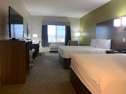 a hotel room with two beds and a flat screen tv at Best Western Plus Horseheads Inn & Suites in Horseheads