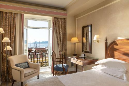 a hotel room with a bed and a desk and a window at As Janelas Verdes Inn - Lisbon Heritage Collection - Riverside in Lisbon