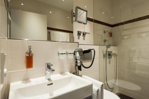 a bathroom with a sink and a shower at Hotel Antares in Munich