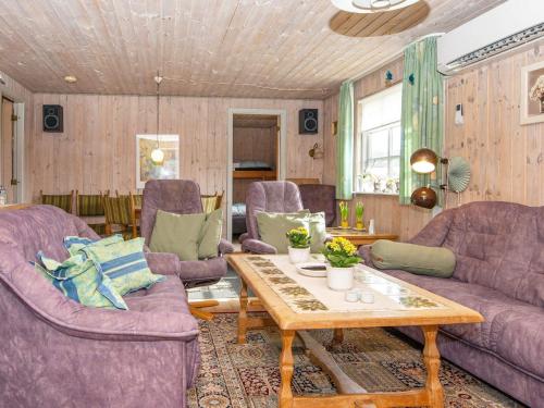 una sala de estar con sofás morados y una mesa de madera. en 9 person holiday home in Grenaa en Grenå