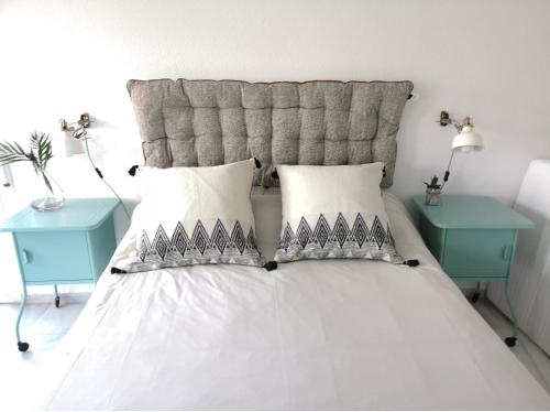 - une chambre avec un lit blanc et 2 tables bleues dans l'établissement Torre con vistas, à Tossa de Mar