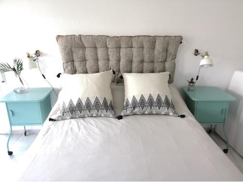 a bedroom with a white bed with two blue tables at Torre con vistas in Tossa de Mar