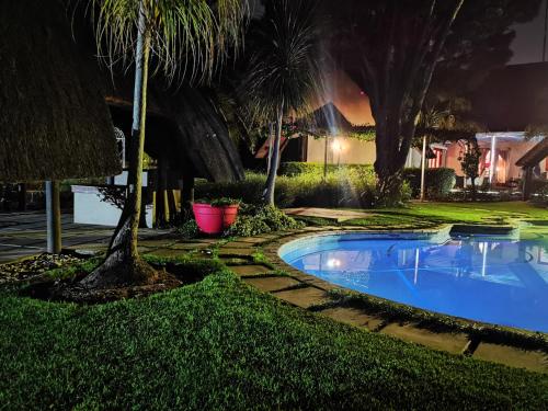 a swimming pool in a yard at night at Lipizzaner Lodge - Kyalami, Midrand in Kyalami
