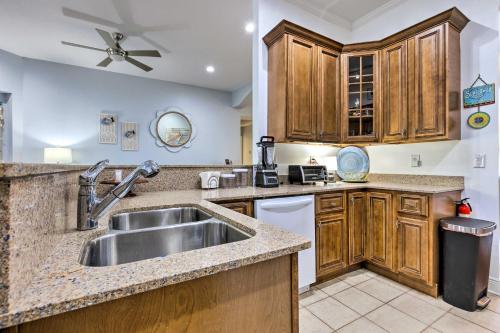 una cocina con armarios de madera y fregadero en Ocean Springs Home with Fire Pit and Game Room! en Biloxi