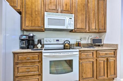 a kitchen with a white stove and a microwave at Ocean Springs Home with Fire Pit and Game Room! in Biloxi